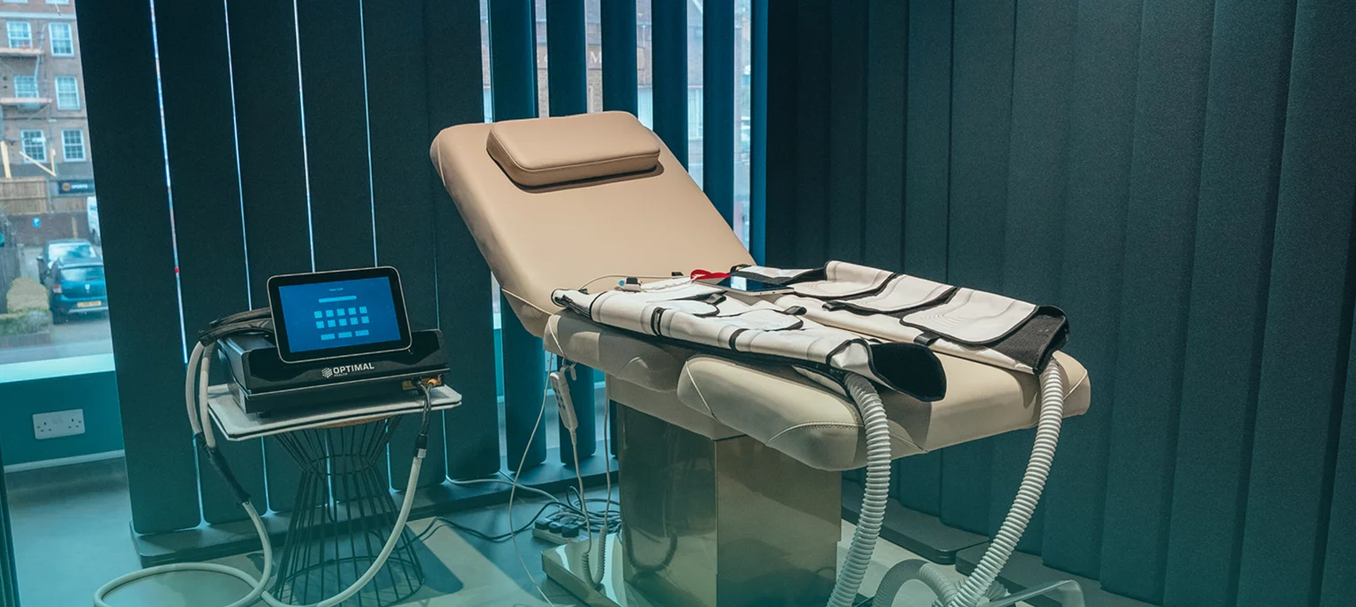 Close up of the Re:nu Optimal compression therapy device and treatment bed with a blue gradient overlay