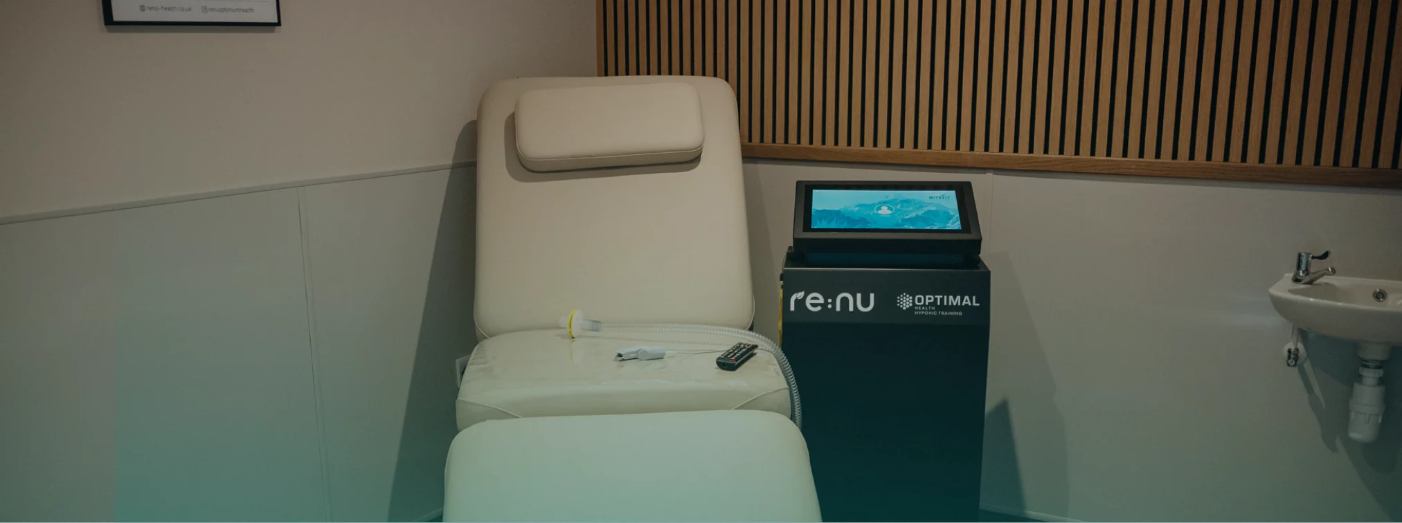 Close up of the Re:nu Optimal hypoxic therapy device and treatment bed with a blue gradient overlay