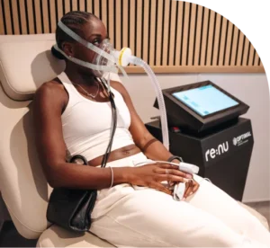 A woman wearing a specialist breathing mask and pulse oximeter during a hypoxic therapy treatment