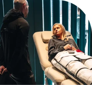 Wellness consultant speaks to a woman wearing compression garments ahead of lymphatic drainage treatment