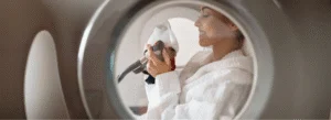 Woman Wearing Woman wearing a white robe smiles as she applied a breathing mask inside a hyperbaric oxygen therapy chamber