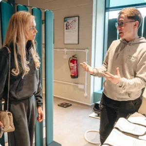 Re:nu London wellness specialist giving a personalised tour and explaining biohacking treatments to a visitor.