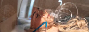 Woman asleep in hyperbaric oxygen therapy chamber
