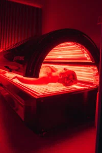 Man sleeping in a red light therapy machine