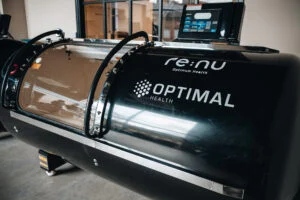 Outside of the Re:nu Optimum Health cryotherapy chamber illuminated in clean blue light