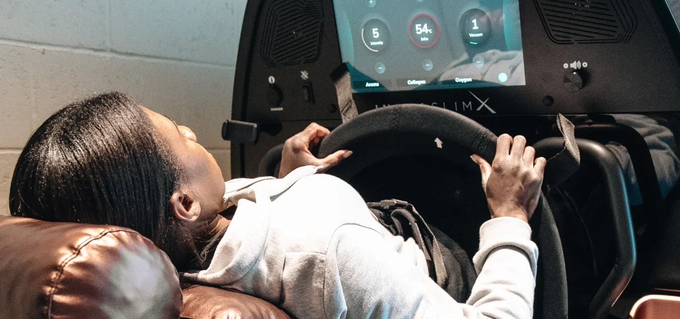 Woman reclined on an INFRASLIMX infrared vacuum bike at Re:nu Optimum Health in London