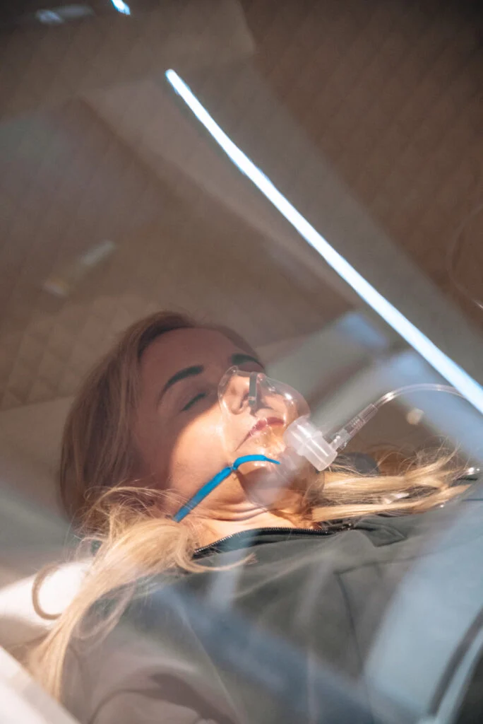 Woman receiving hyperbaric oxygen therapy for cellular repair in London.