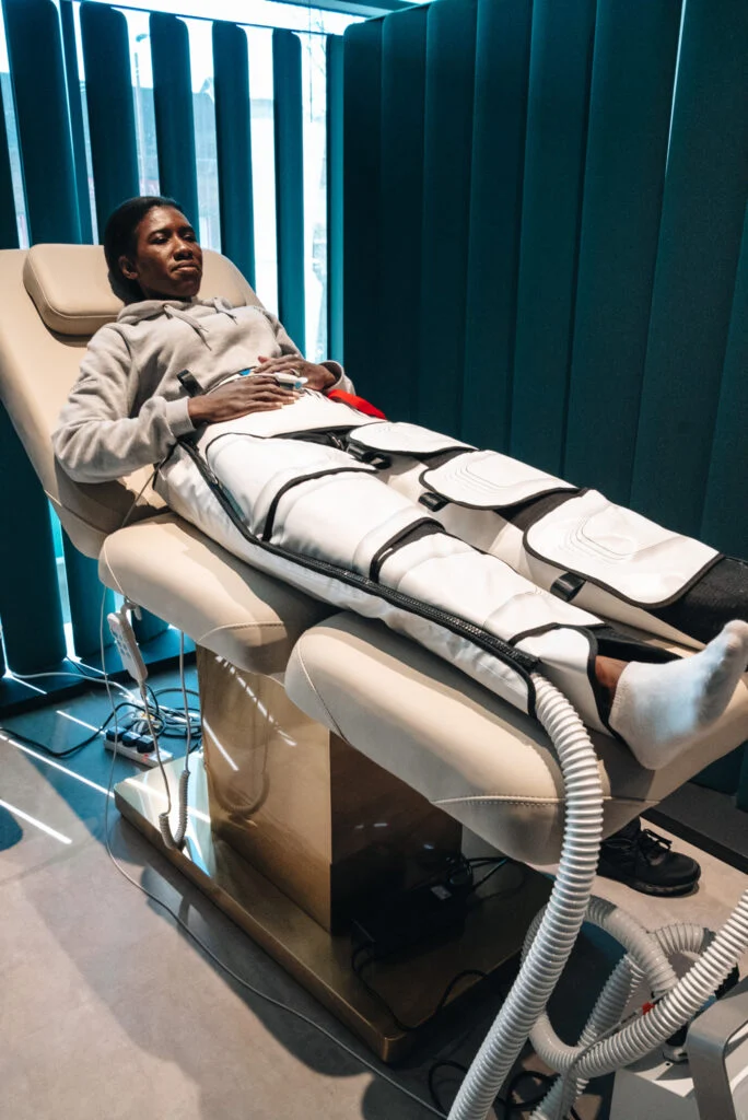 Customer using a lower body compression therapy device to treat DOMS at the Re:nu wellness centre in London