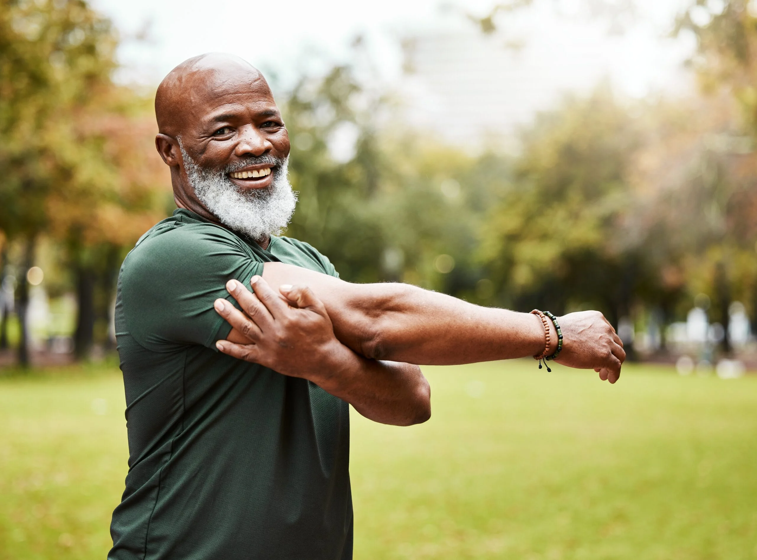 Active older man stretching outdoors, representing healthy ageing and longevity lifestyle