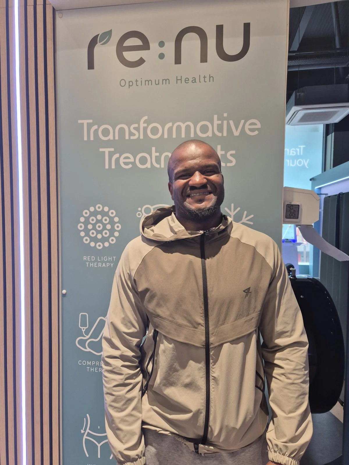 Member of Re:nu wellness community in London smiling in the reception area.