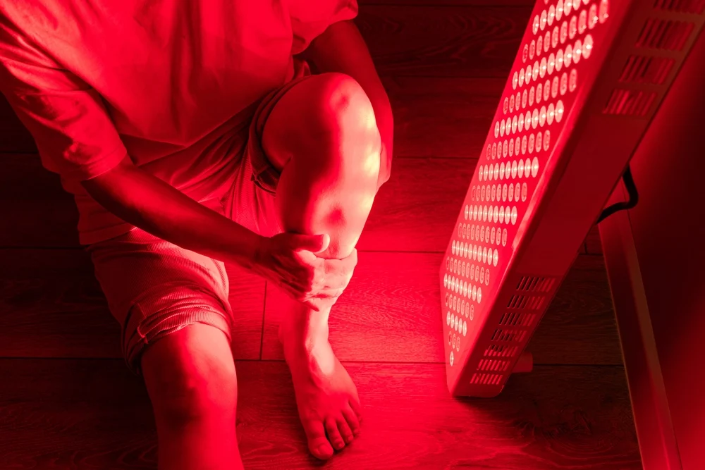 Client receiving red light therapy for knee pain and joint inflammation at Re:nu London